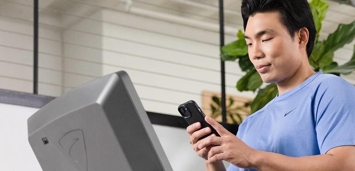 Person holding phone standing in front of Vision console