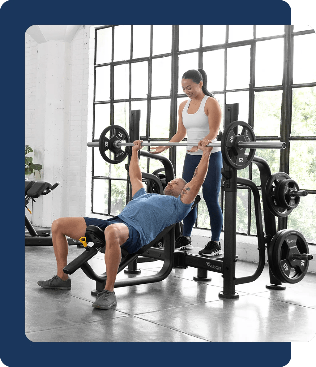 A person spotting another person that is using the incline bench press