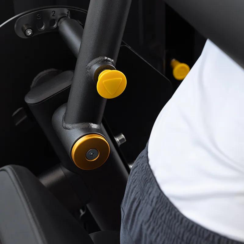 Close-up of a user adjusting the pivot point on the Vision Fitness Back Extension machine using the yellow adjustment knob.