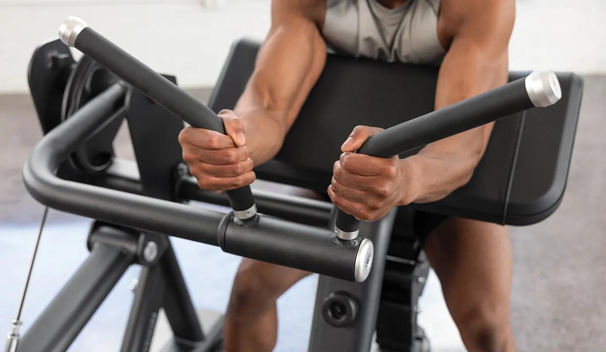 A person gripping both rubber handles with their arms resting on the pad for support.