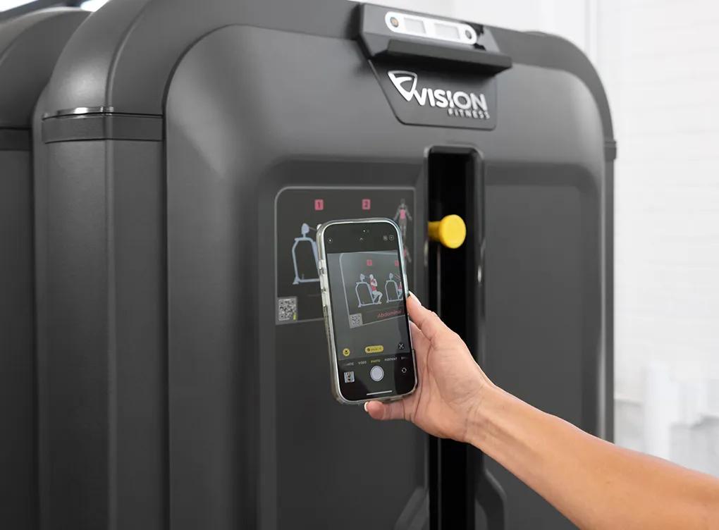 A person using their phone to scan the QR code on a Vision weight machine