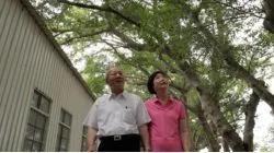 Founder Peter Lo and his wife walking on a tree-lined street.