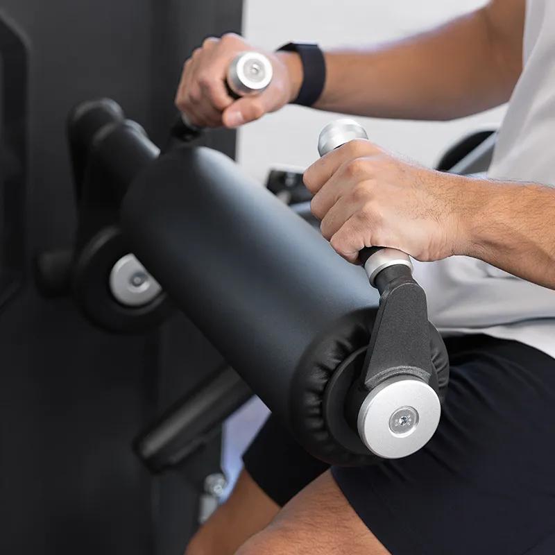 Close-up of a man gripping the handles on the Keystone Glute Trainer's foam rollers.