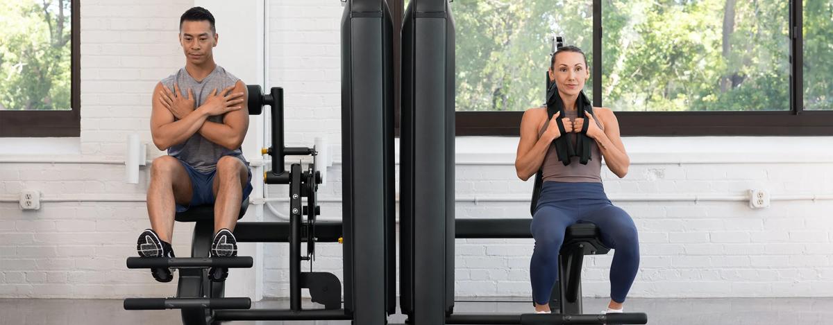 Person using the Vision Fitness Abdominal machine, performing a seated crunch with the cable-connected shoulder harness engaged.
