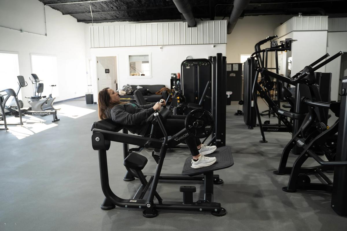 Person using the Vision Glute Trainer machine in a gym.