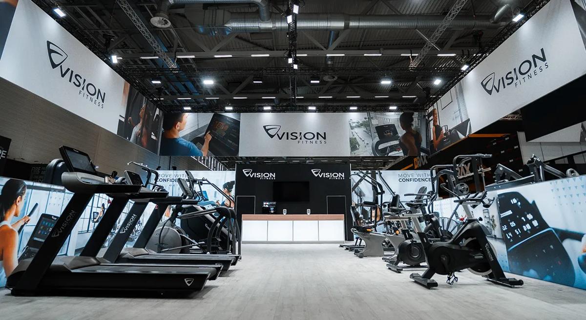 Entry view of the Vision tradeshow booth at FIBO with treadmills on the left side and indoor cycle on the right.