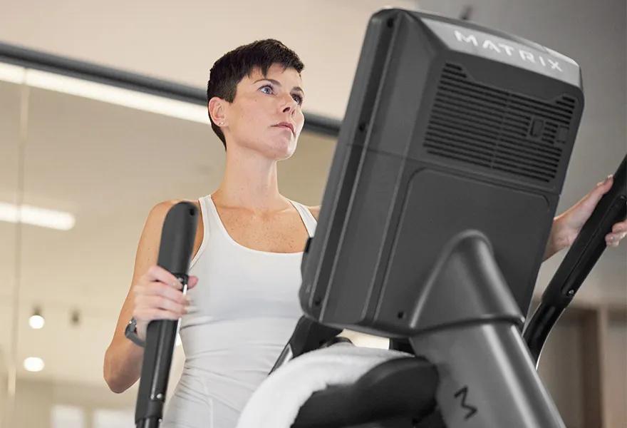 Woman on Matrix elliptical machine mid-stride
