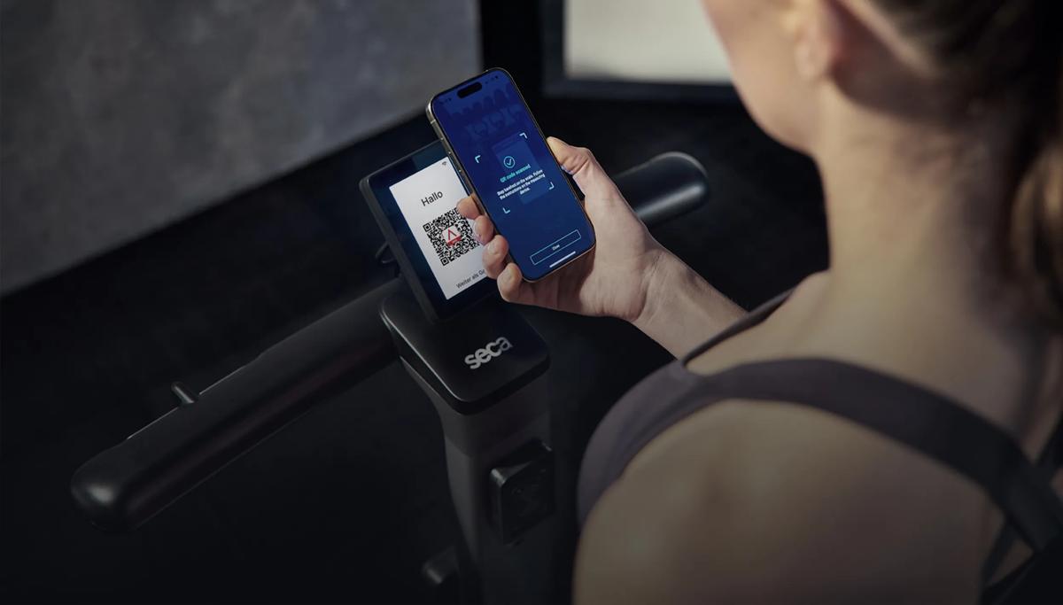 Una persona che tiene il telefono sopra un codice QR su un prodotto seca.