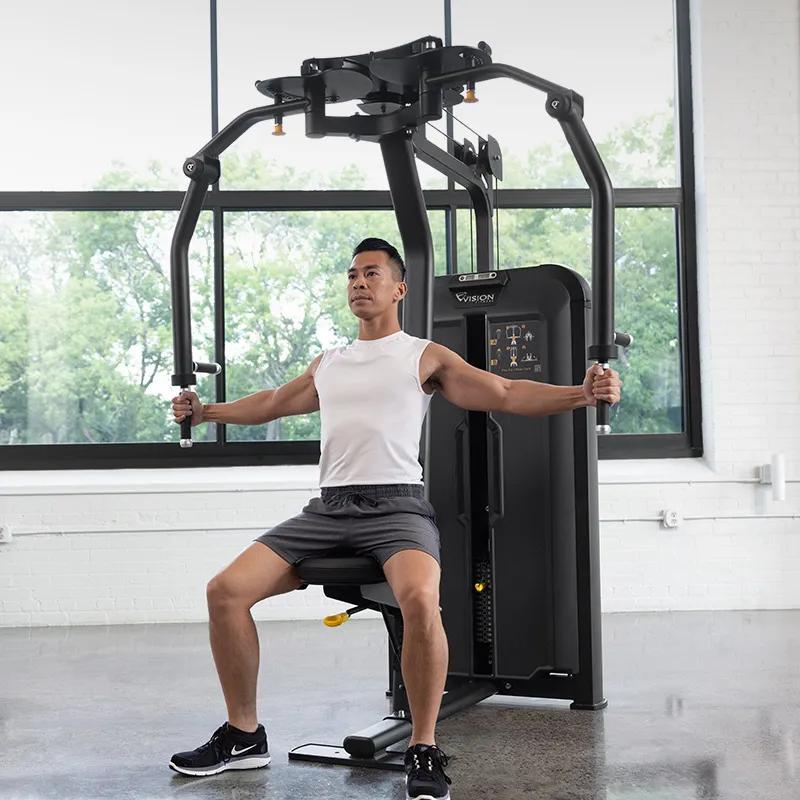 Person seated on the Vision Fitness Pec Fly/Rear Delt machine with arms extended outward, preparing to perform a rear delt fly exercise.