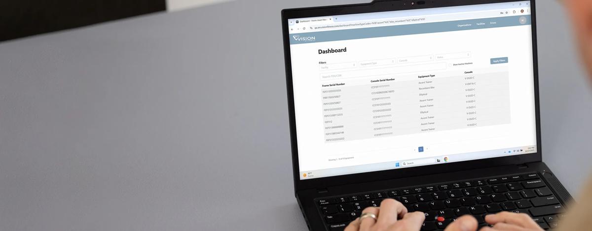 A person using the Vision Asset Management System on an open laptop