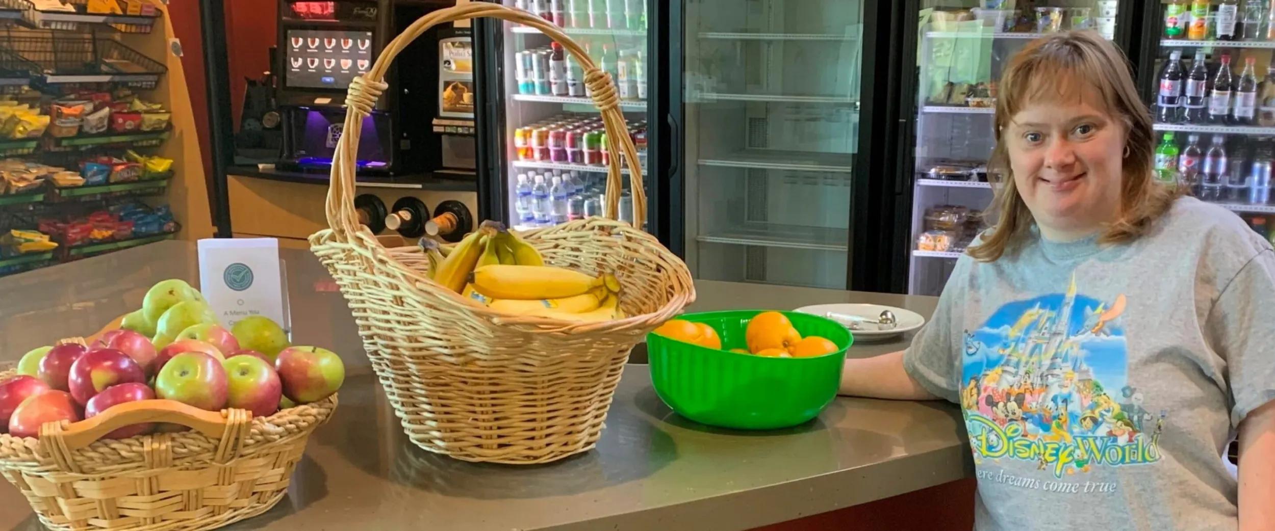 Johnson Health Tech employee smiling next to baskets of fruit.