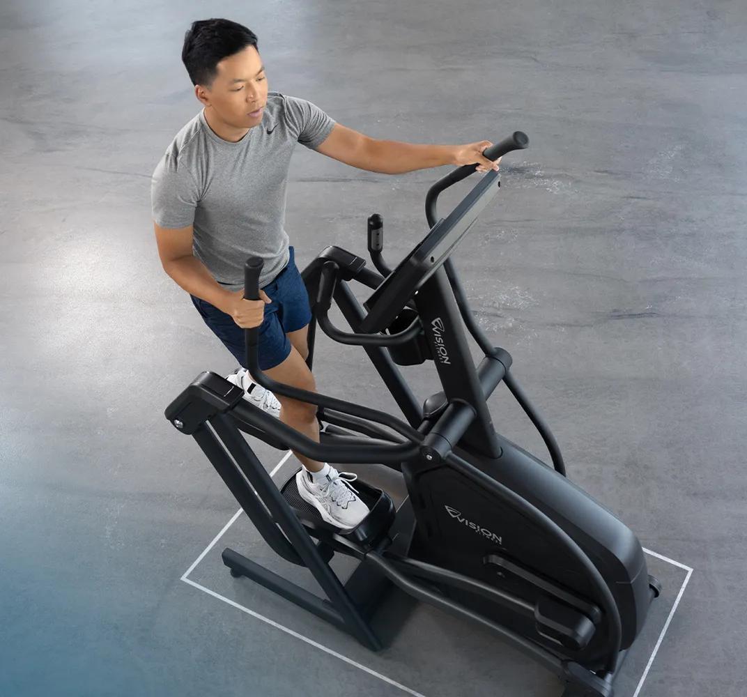 Full view of a person using the Summit Suspension Elliptical in a gym setting.