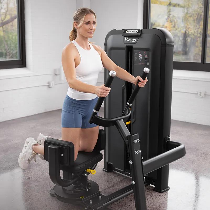 Person using the Keystone Rotary Torso machine, kneeling with hands on the handles and torso rotated to one side to engage the core muscles.