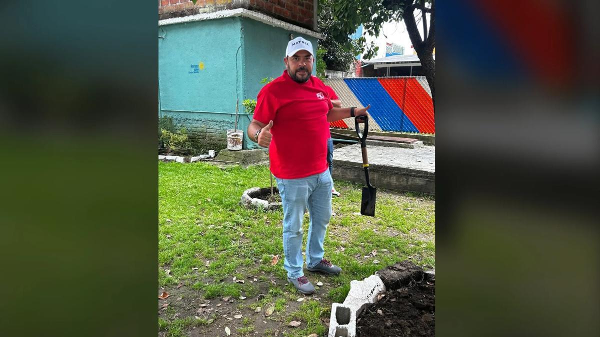 Man outside holding a shovel while giving a thumbs up.