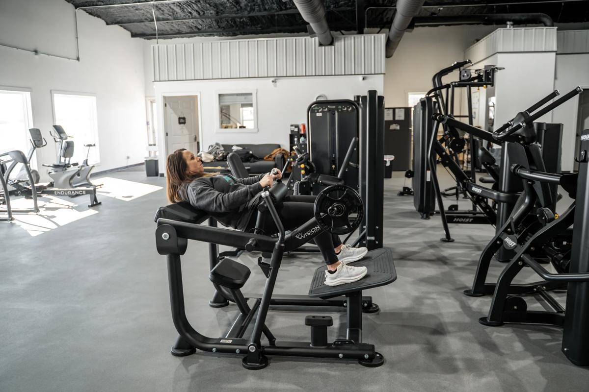 Person using the Vision Glute Trainer machine in a gym.