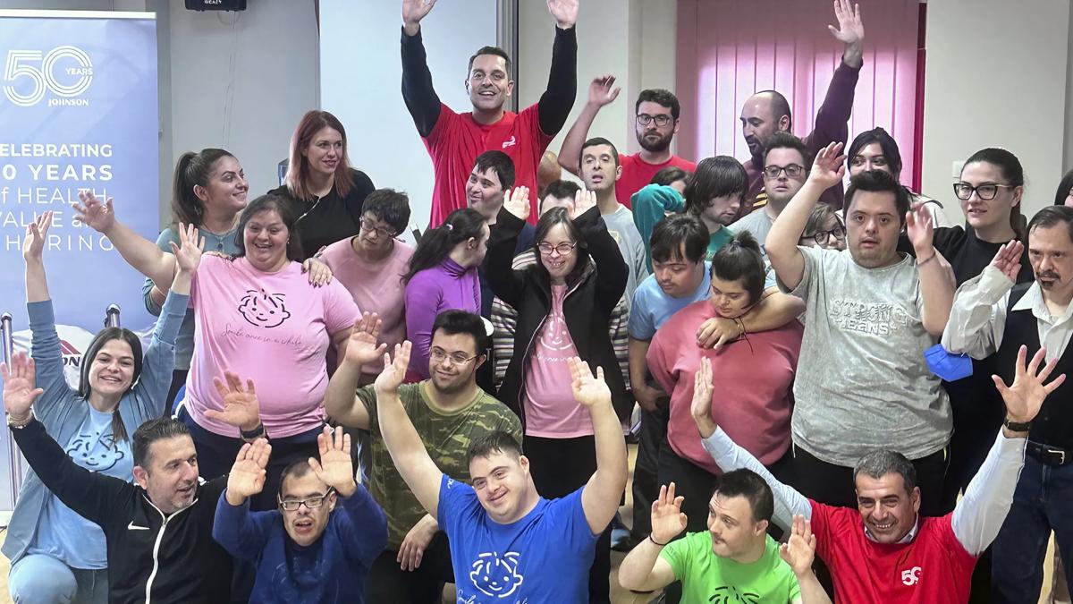 A group of people smiling and holding their hands in the air.