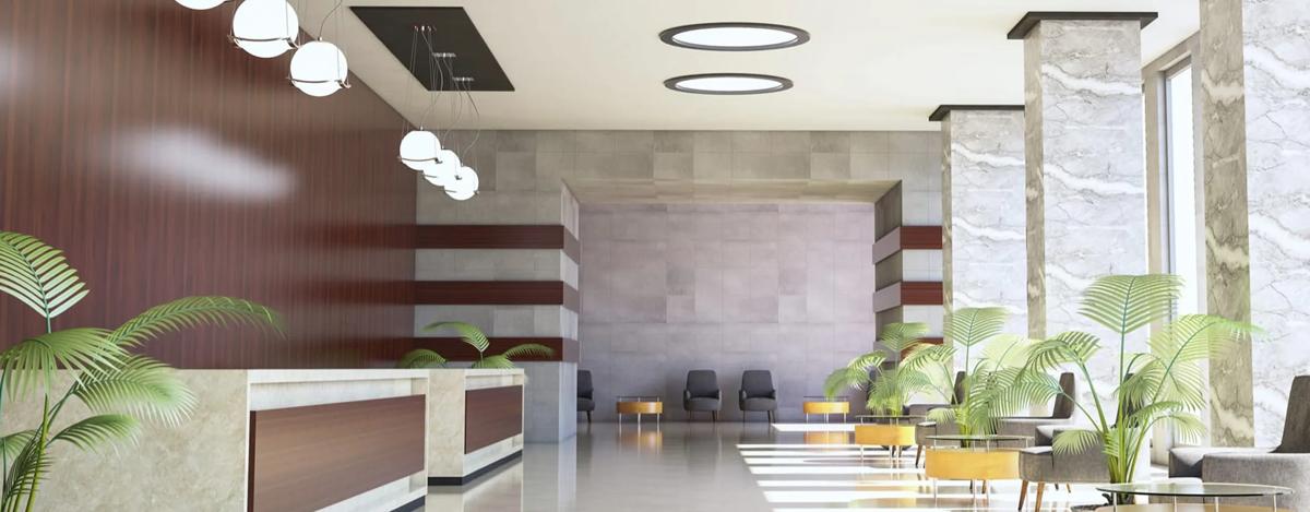 Empty, well-lit hotel lobby with marble floors and walls.