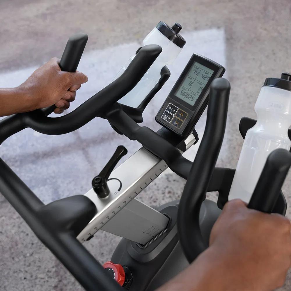 A close-up of a person holding the handlebar area on the IC700 Indoor Cycle.