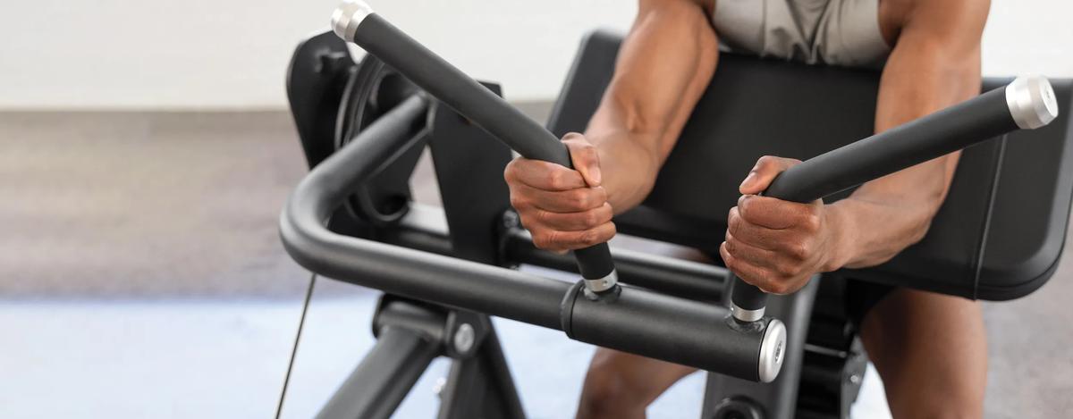 A person gripping both rubber handles with their arms resting on the pad for support.