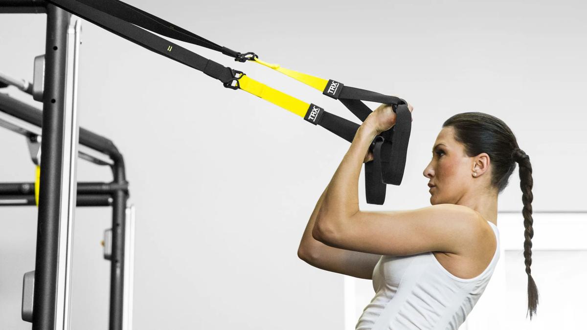 Woman using Connexus with TRX straps