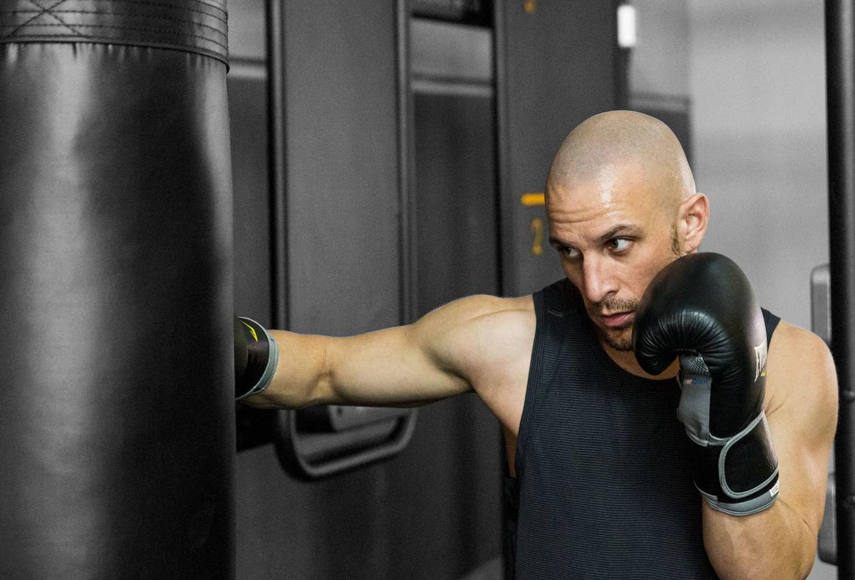 Boxer dávající údery do pytle s pískem připojeného k systému Connexus