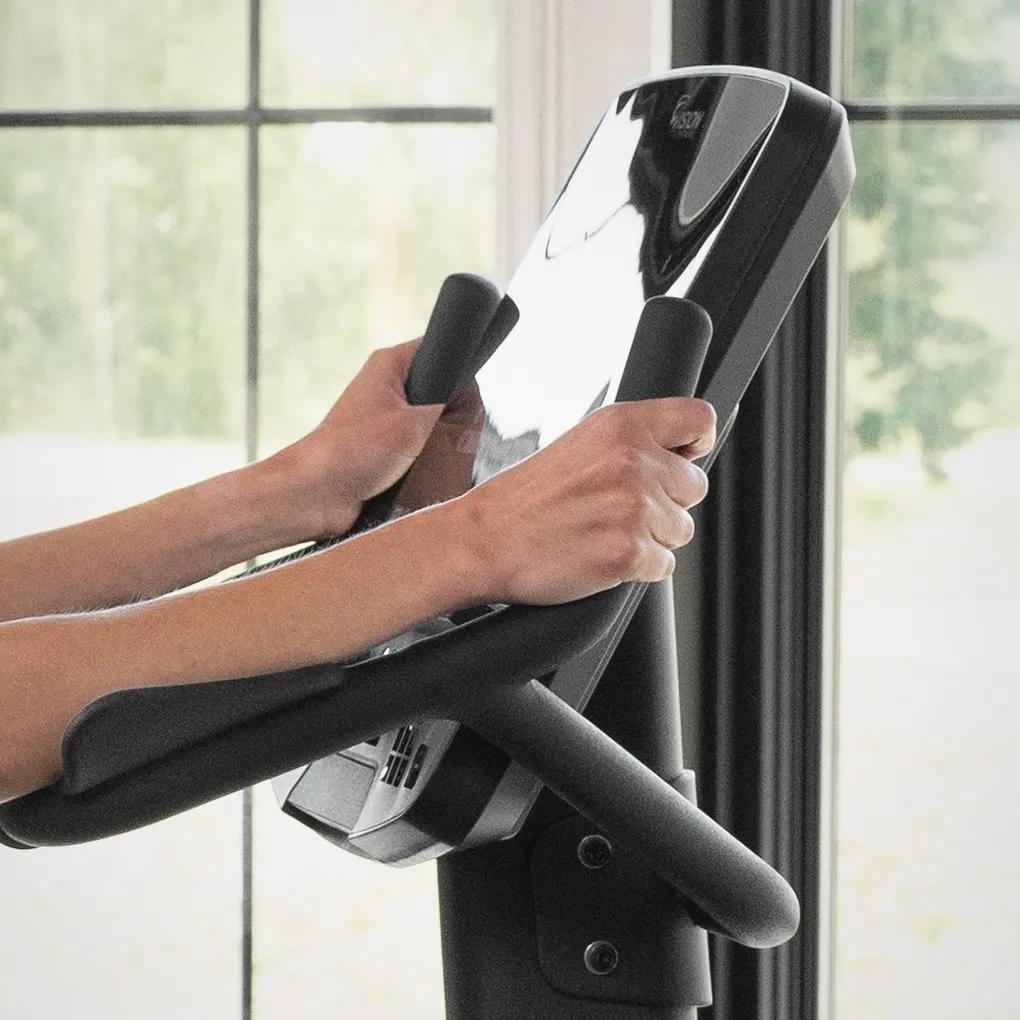 Close-up view of a person using the Summit Upright Bike, focusing on its handles.