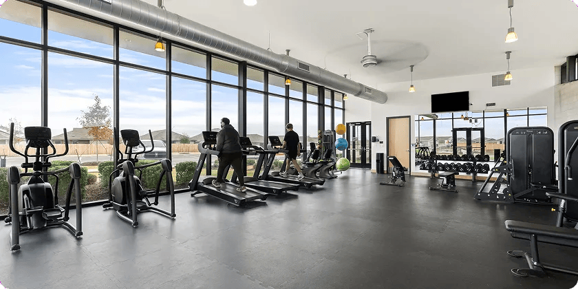 People working out in a gym on Vision Fitness cardio equipment.
