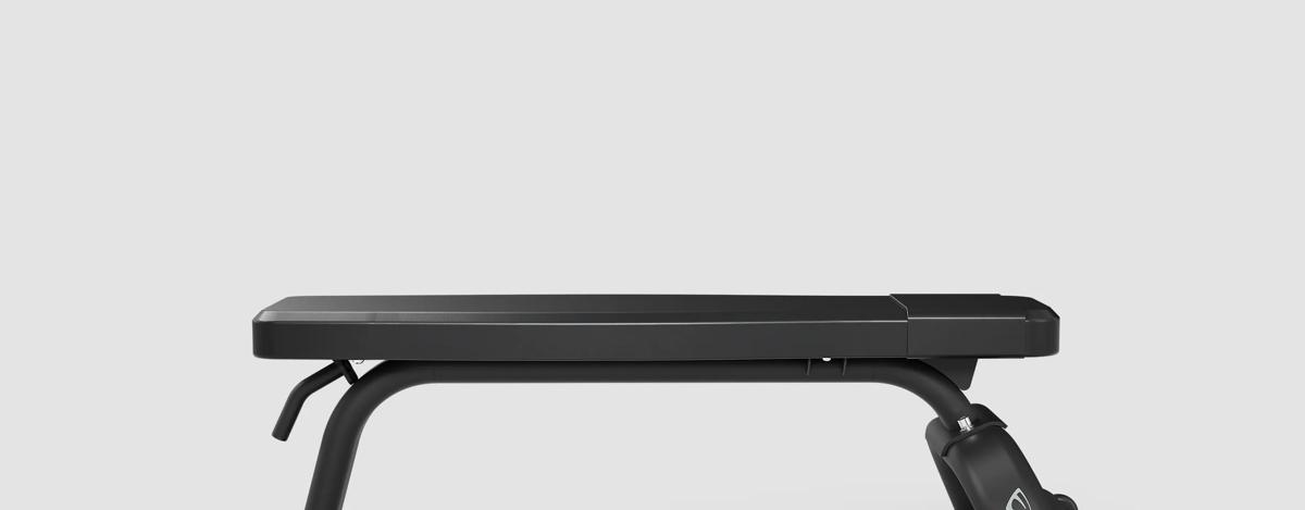 Side view of a Matte Black free weight Flat Bench's polyurethane foam pads and wide back pad.