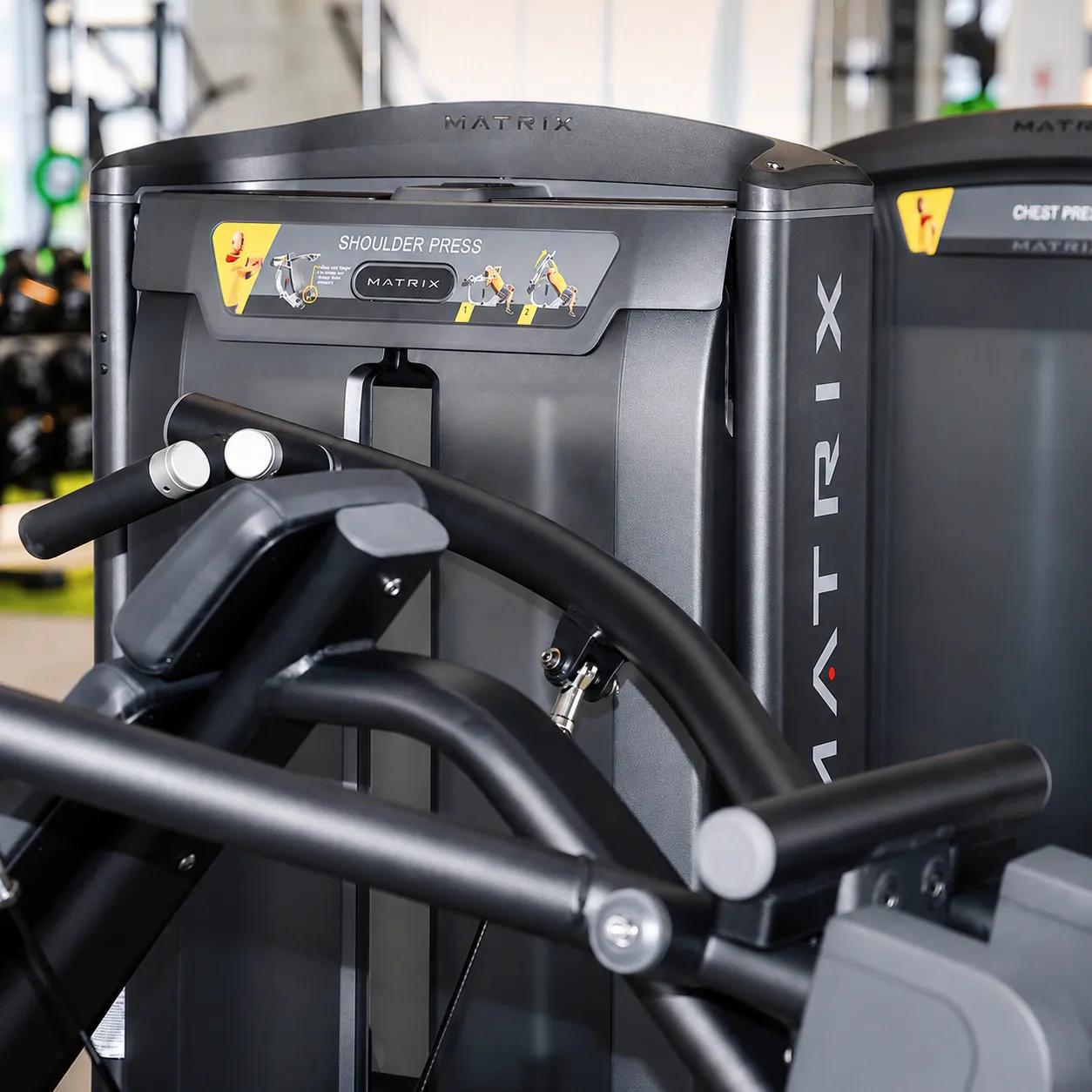 Matzwarte Matrix Fitness-shoulderpressmachine in close-up, met de nadruk op de oefeninstructies en het ontwerp voor krachttraining van het bovenlichaam.