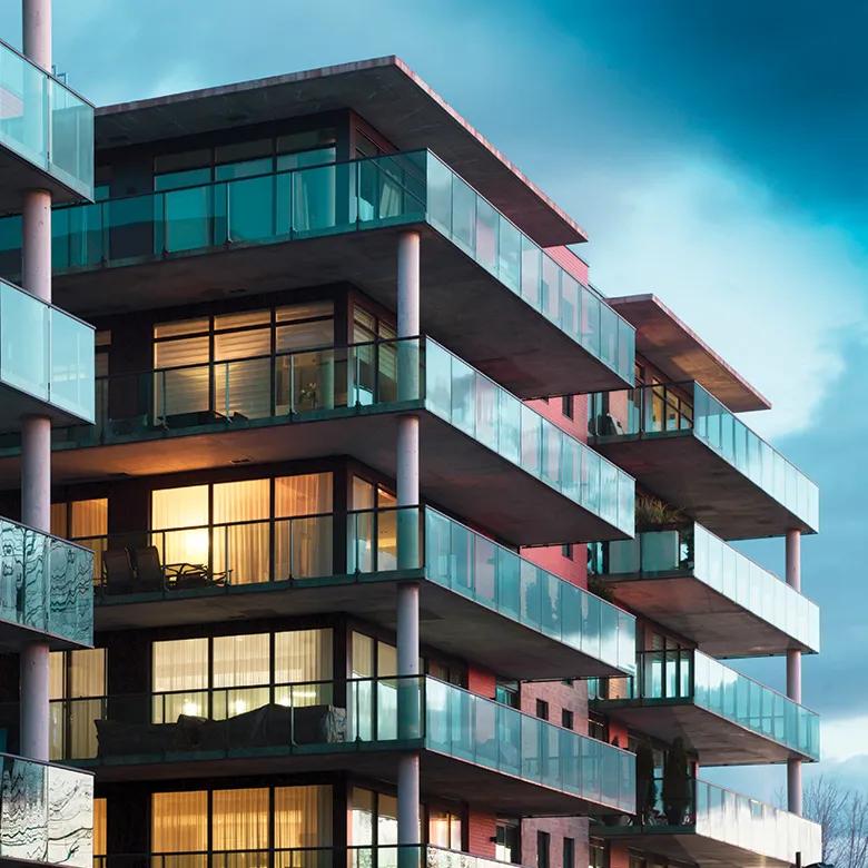 Una vista exterior de un bonito complejo de apartamentos al anochecer