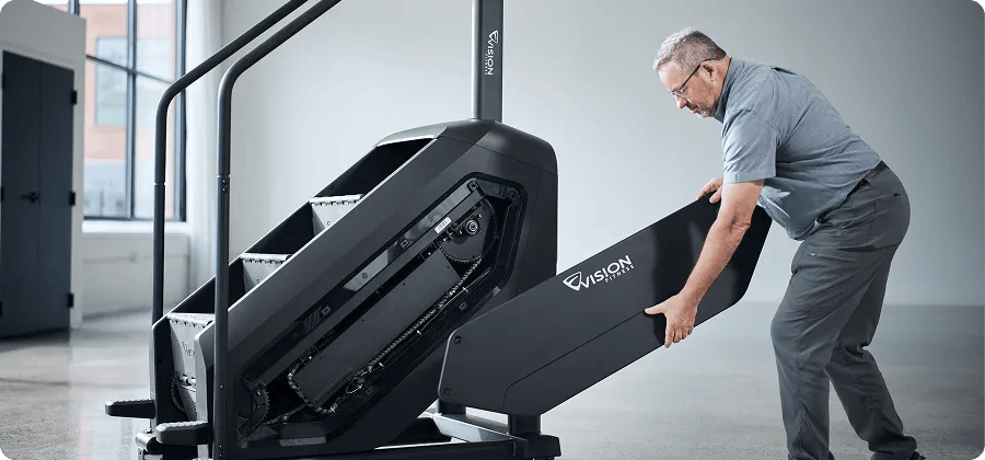 Maintenance man fixing the Vision Summit Stairclimber.