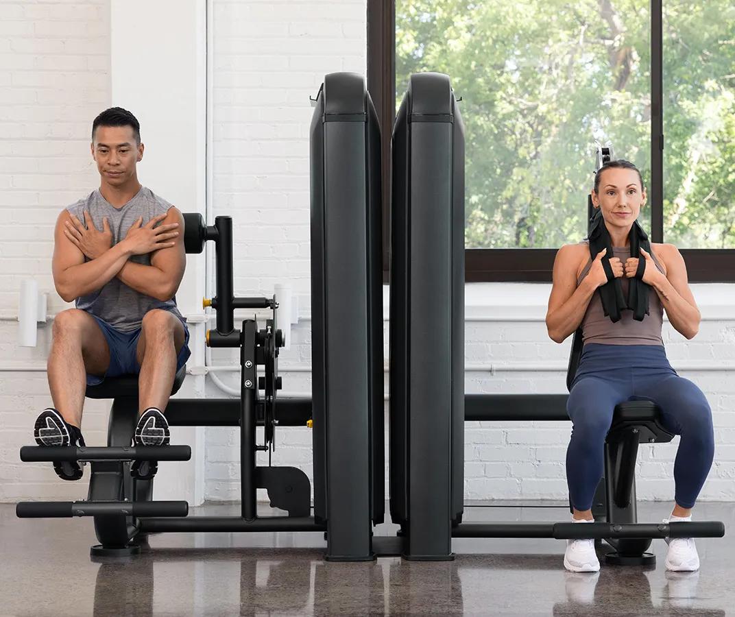 Person using the Vision Fitness Abdominal machine, performing a seated crunch with the cable-connected shoulder harness engaged.