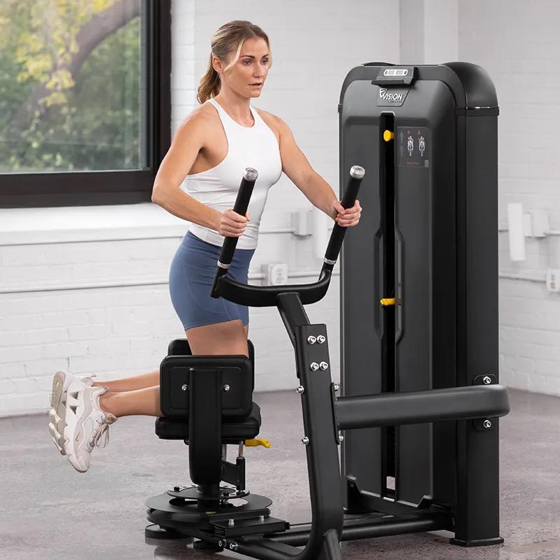 Person on the Keystone Rotary Torso machine in a rotated position, holding the handles with hips braced and legs elevated to demonstrate full torso rotation.