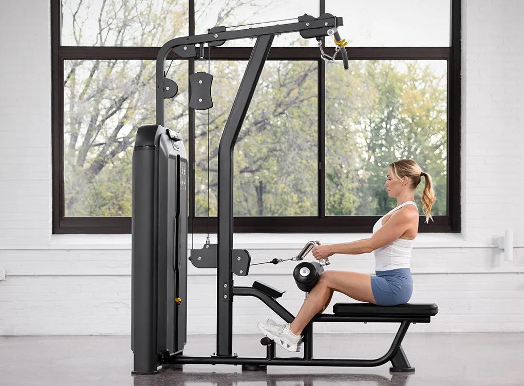 Person seated on the Keystone Lat Pulldown / Seated Row machine, holding the cable attachment in the starting position for a rowing exercise.