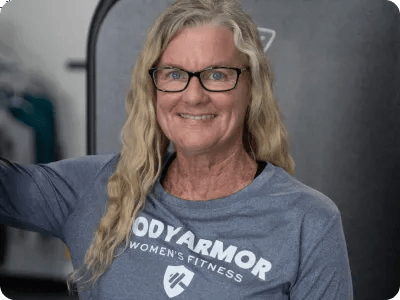 Professional photos of Amy in a Bodyarmer fitness long sleeve smiling in front of a Vision machine