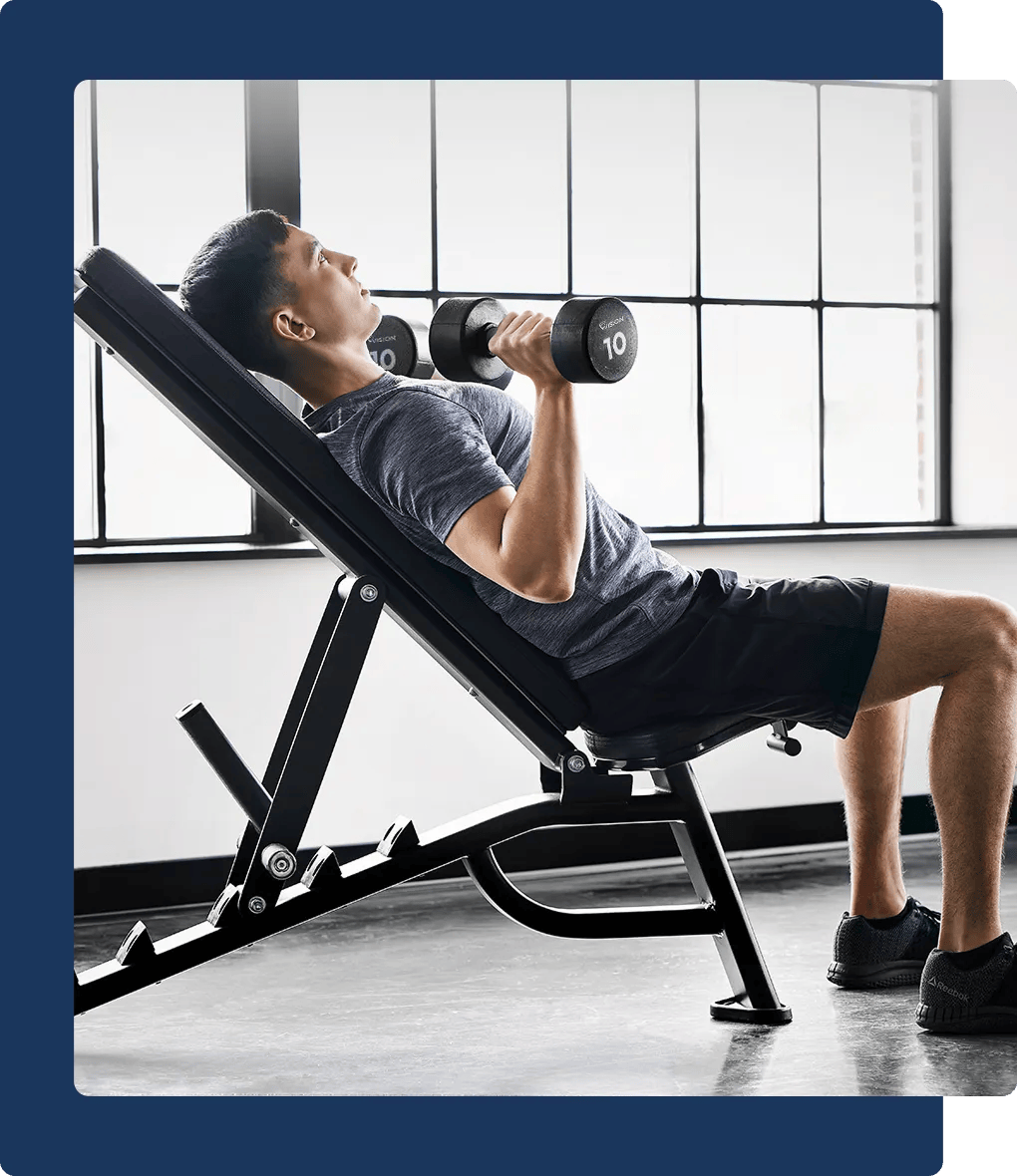 A person using free weights on a weight bench.