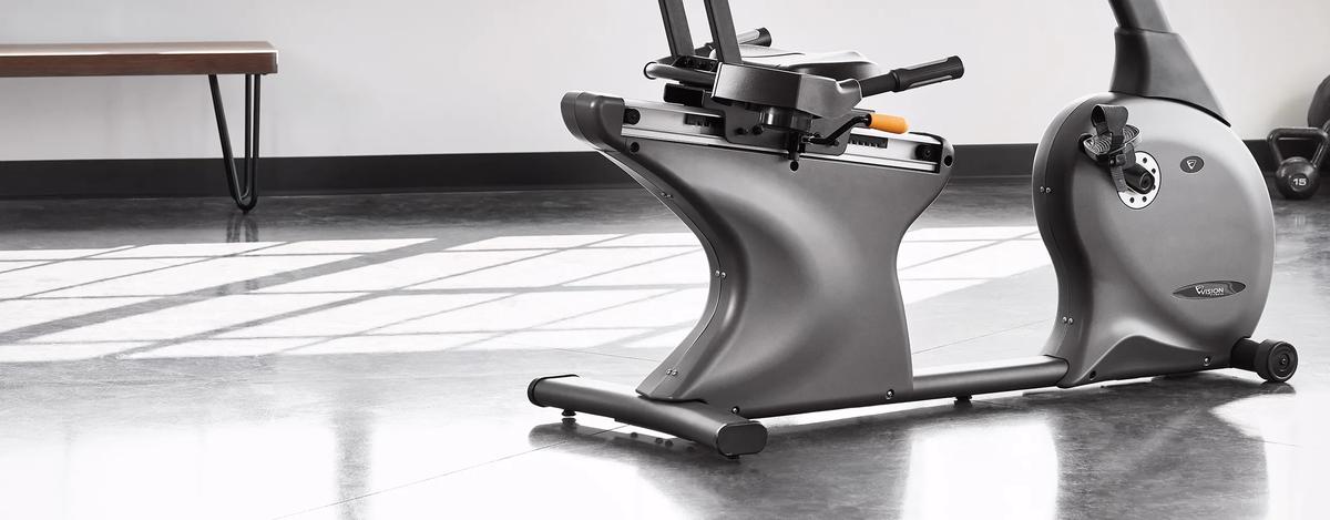 A Recumbent Bike in a bright, modern gym with a minimalist design and natural light casting shadows on the floor.
