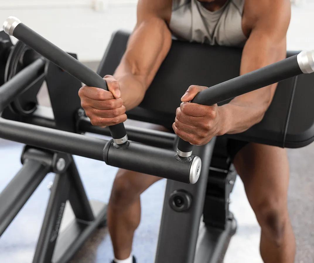 A person gripping both rubber handles with their arms resting on the pad for support.