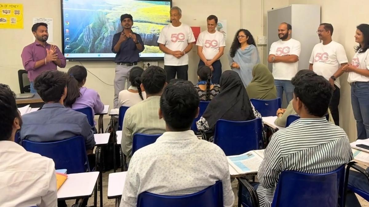 A group of people standing in front of a classroom full of people.