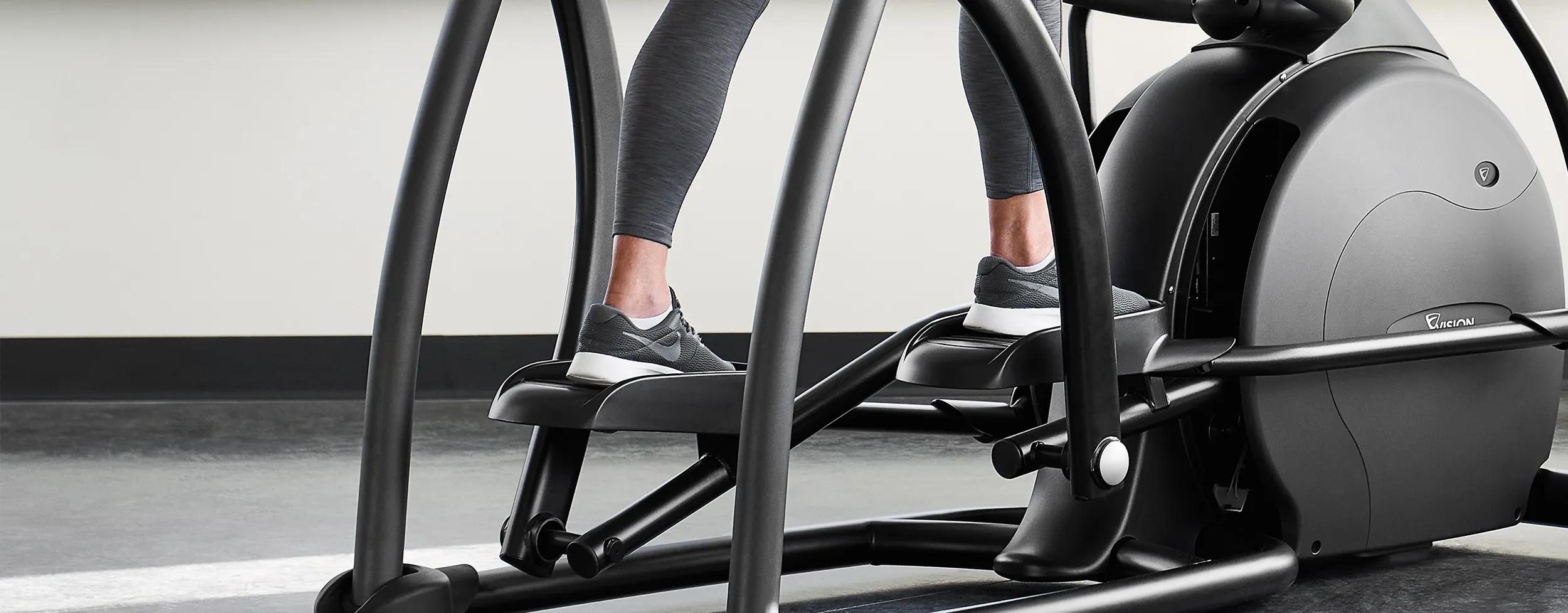 Vision Fitness 橢圓機腳踏板上的一個人的腳特寫。