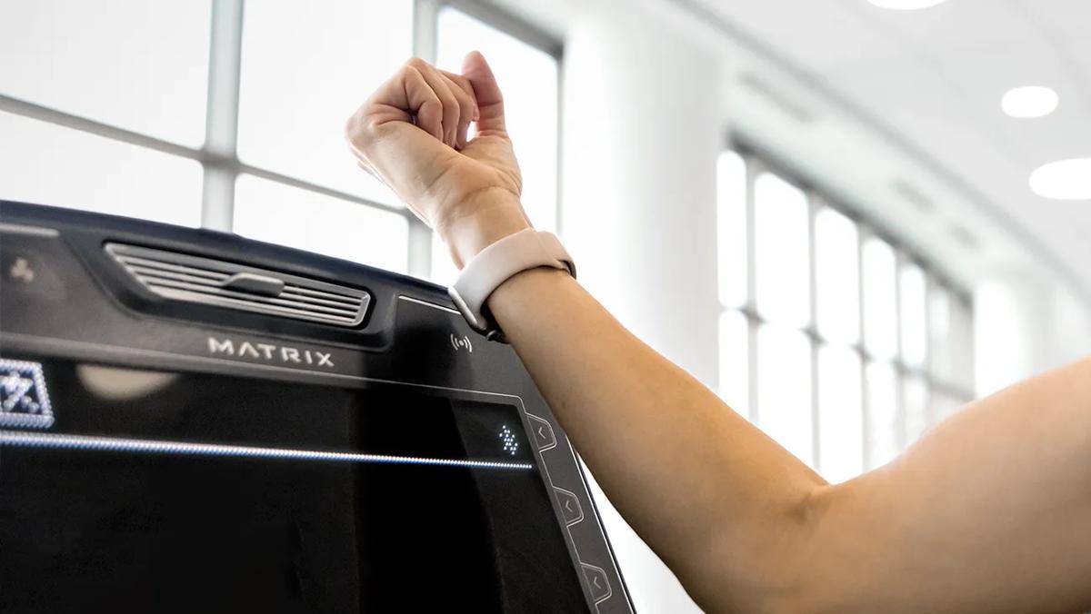 Una persona utilizza il proprio braccialetto RFID per accedere alla console.