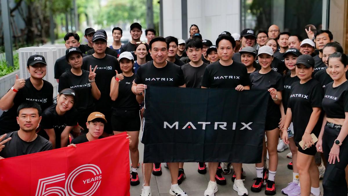 Large group of people wearing Matrix t-shirts and holding a Matrix banner.